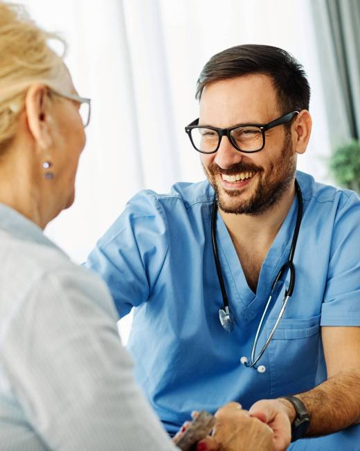 Doctor or nurse caregiver with senior woman at home or nursing home